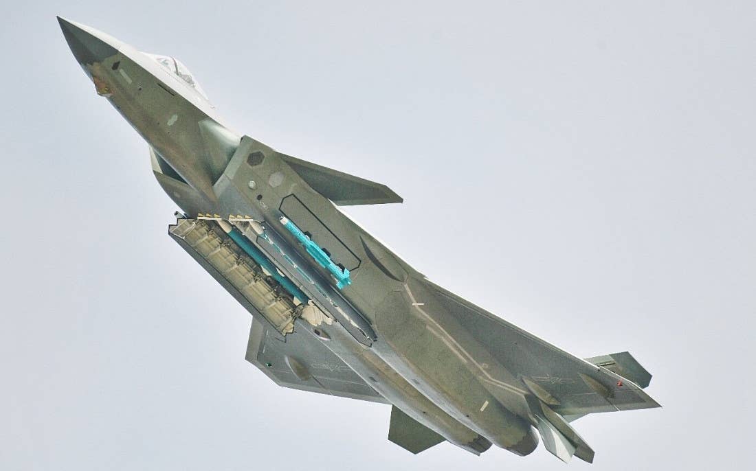 A J-20 with the weapon bays under its fuselage open, showing PL-15 air-to-air missiles. An inert PL-10 air-to-air missile loaded inside its right cheek bay is also seen here in the ready-to-fire position. <em>Chinese internet</em>