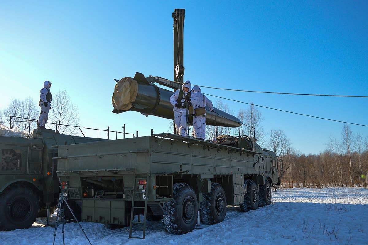 A nuclear-capable Iskander-M short-range ballistic missile is being loaded onto a transporter-erector-launcher. <em>Russian MOD</em>