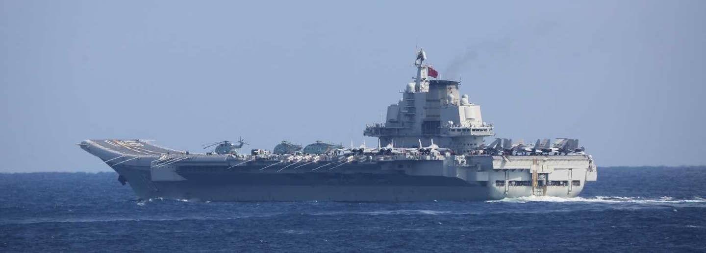 The carrier <em>Liaoning</em> photographed from a Japan Maritime Self-Defense Force ship that was shadowing it approximately 180 miles east of Kitadaito Island, Okinawa, in December 2021. <em>JMSDF</em>