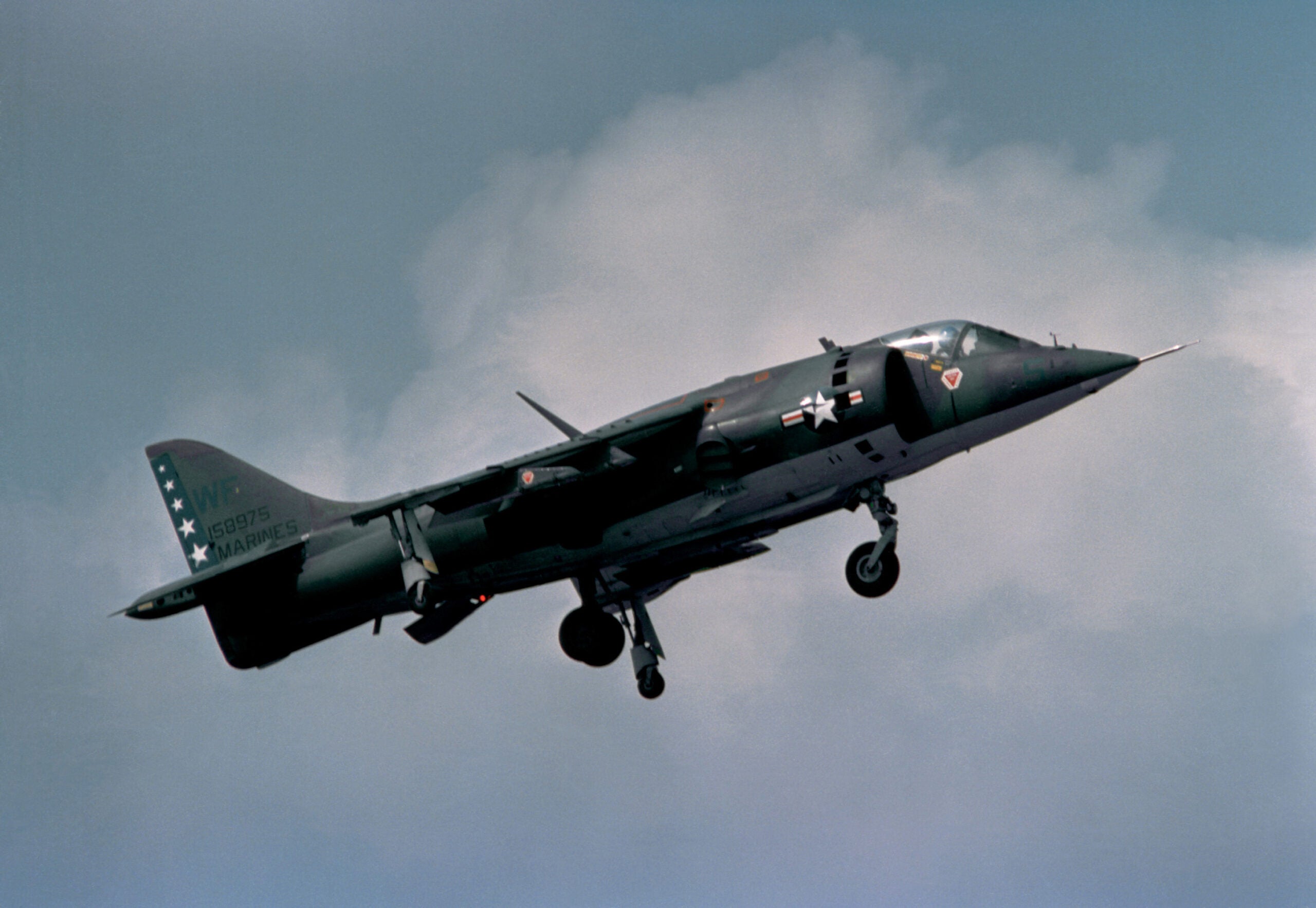 A ground-to-air right side view of a Marine AV-8A Harrier aircraft preparing to land.  The Harrier is from Marine Light Attack Squadron 513 (VMLA-513).
