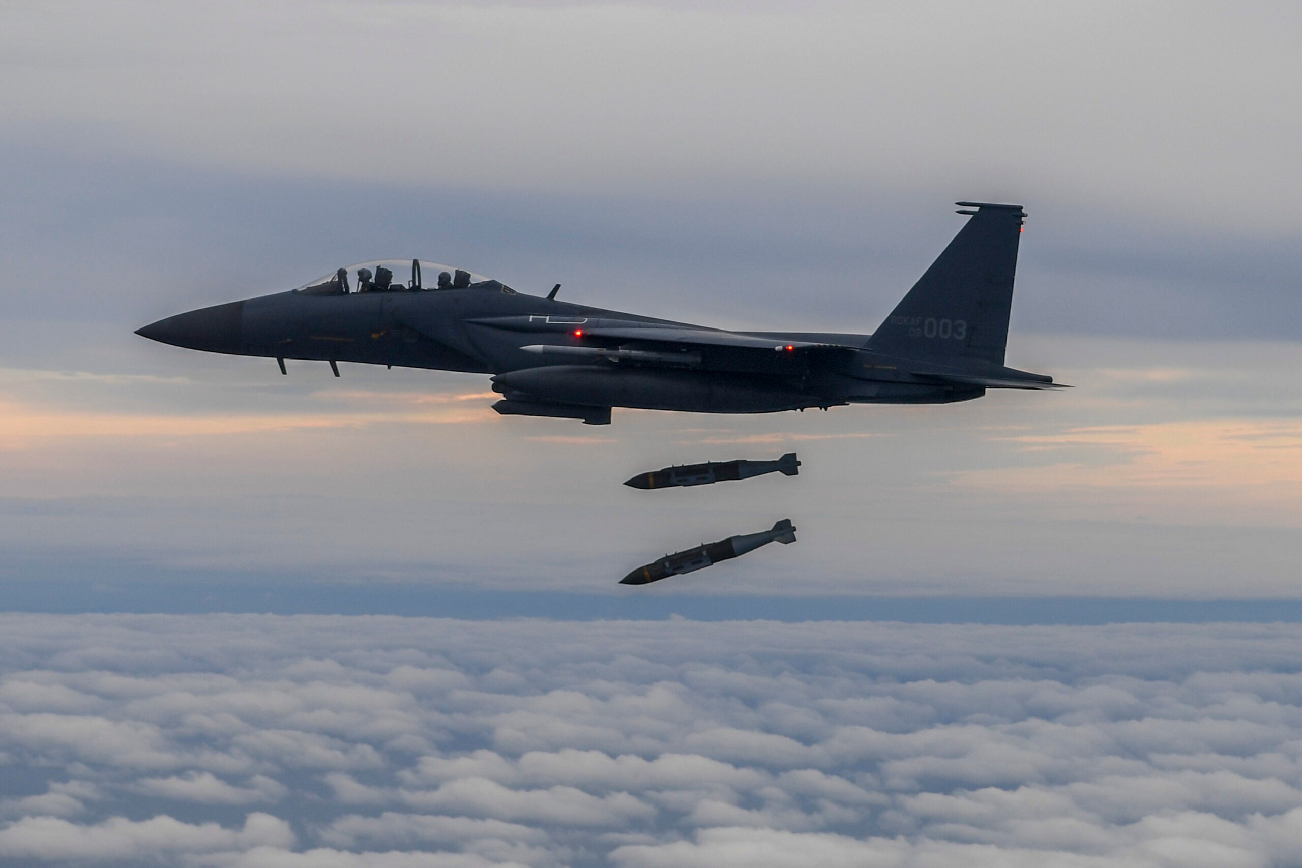 UNDISCLOSED LOCATION - OCTOBER 04: In this handout image released by the South Korean Defense Ministry, A South Korean F-15K fighter fires two Joint Direct Attack Munition (JADAM) bombs into an island target in response to North Korea's intermediate-range ballistic missile (IRBM) launch earlier in the day, on October 04, 2022 at an undisclosed location. North Korea fired an intermediate-range ballistic missile (IRBM) over Japan on Tuesday in its first launch of an IRBM in eight months, according to South Korea’s military. (Photo by South Korean Defense Ministry via Getty Images)