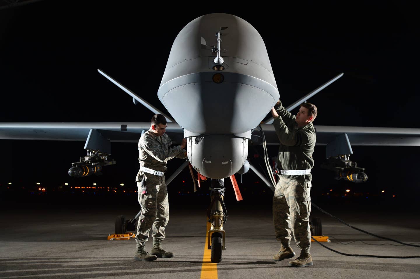 Airman 1st Class Steven (left) and Airman 1st Class Taylor prepare an MQ-9 Reaper for flight during exercise Combat Hammer, May 15, 2014, AGM-114 Hellfire munitions can be seen under the wings. <em>Credit: U.S. Air Force photo/Staff Sgt. Nadine Barclay</em>