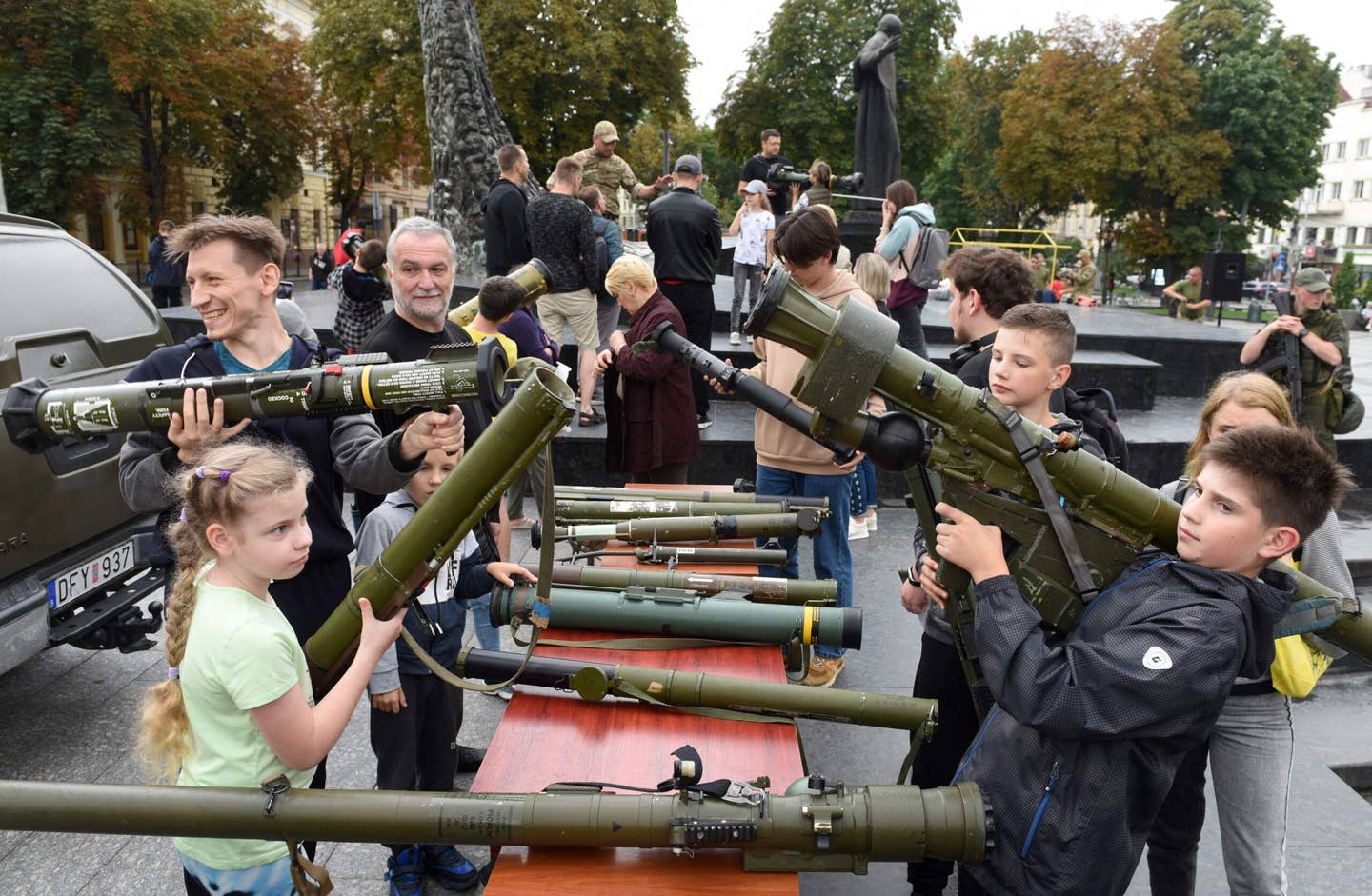 People hold used anti-tank and anti-aircraft military equipment such as Javelin, NLAW, Stinger and other, which were used by Ukrainian military in the fights with the Russian army, and are displayed in an outdoor exhibition in the western Ukrainian city of Lviv on Aug. 12. (Photo by Yuriy Dyachyshyn / AFP) (Photo by YURIY DYACHYSHYN/AFP via Getty Images)