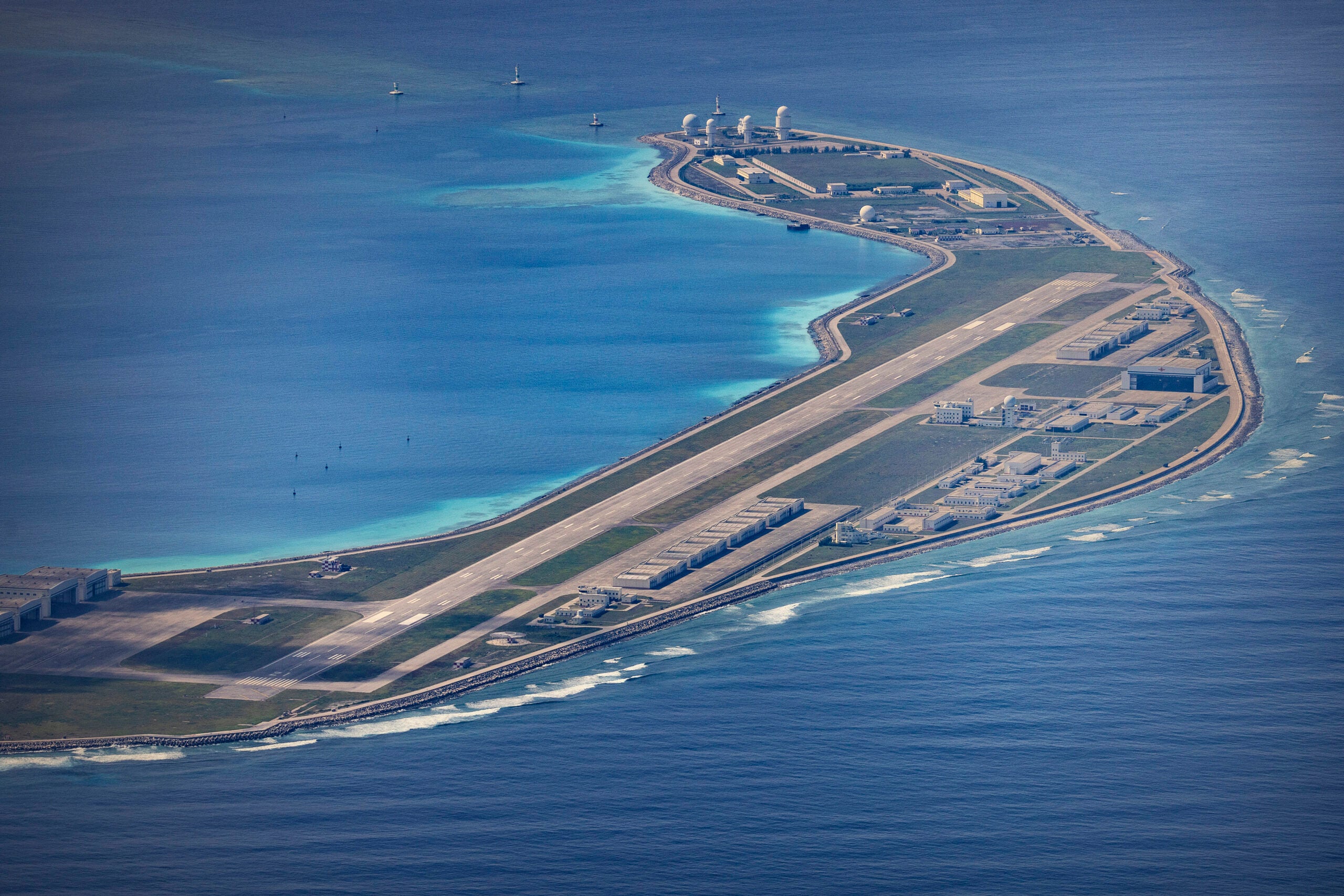 SPRATLY ISLANDS, AT SEA - OCTOBER 25: An airfield, buildings, and structures are seen on the artificial island built by China in Mischief Reef on October 25, 2022 in Spratly Islands, South China Sea. China has progressively asserted its claim of ownership over disputed islands in the South China Sea by artificially increasing the size of islands, creating new islands and building ports, military outposts and airstrips. The South China sea is an important trade route and is of significant interest as geopolitical tensions remain high in the region. (Photo by Ezra Acayan/Getty Images)