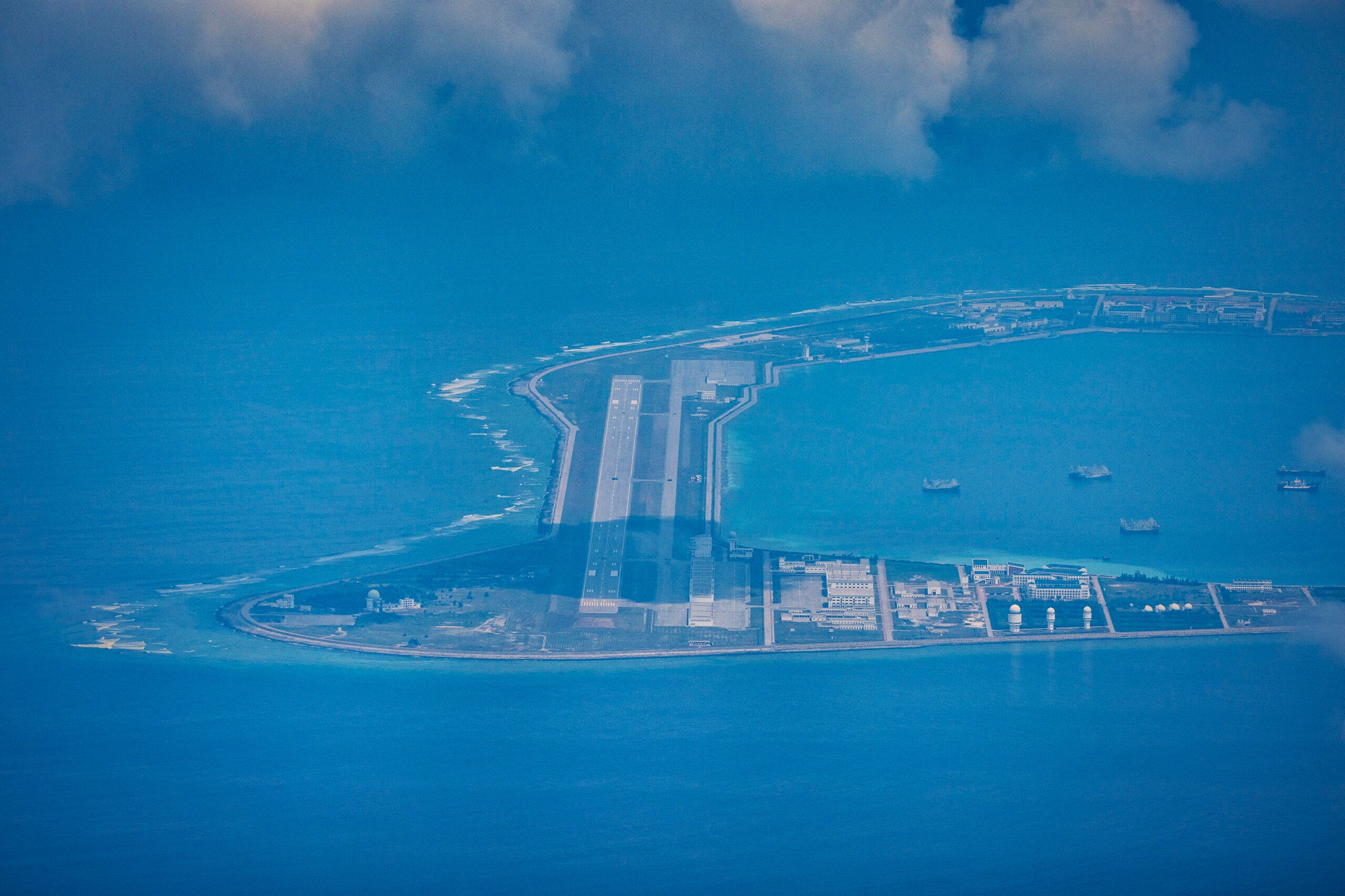 SPRATLY ISLANDS, AT SEA - OCTOBER 25: An airfield, buildings, and structures are seen on the artificial island built by China in Subi Reef on October 25, 2022 in Spratly Islands, South China Sea. China has progressively asserted its claim of ownership over disputed islands in the South China Sea by artificially increasing the size of islands, creating new islands and building ports, military outposts and airstrips. The South China sea is an important trade route and is of significant interest as geopolitical tensions remain high in the region. (Photo by Ezra Acayan/Getty Images)
