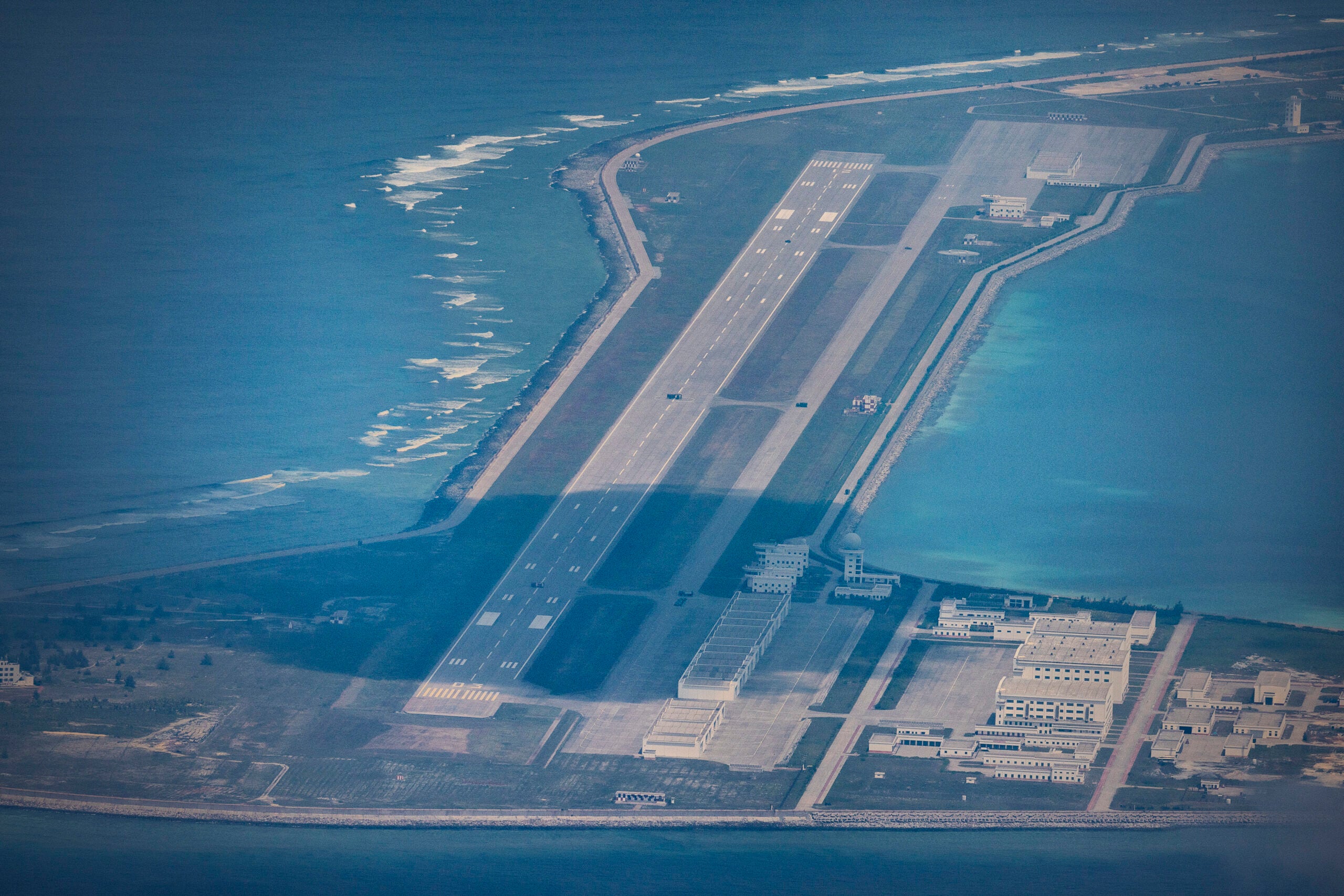 SPRATLY ISLANDS, AT SEA - OCTOBER 25: An airfield, buildings, and structures are seen on the artificial island built by China in Subi Reef on October 25, 2022 in Spratly Islands, South China Sea. China has progressively asserted its claim of ownership over disputed islands in the South China Sea by artificially increasing the size of islands, creating new islands and building ports, military outposts and airstrips. The South China sea is an important trade route and is of significant interest as geopolitical tensions remain high in the region. (Photo by Ezra Acayan/Getty Images)
