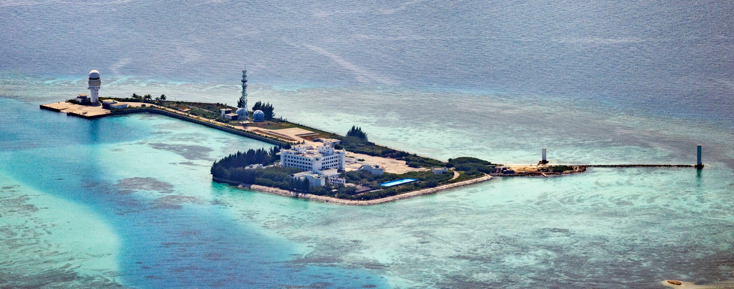 SPRATLY ISLANDS, AT SEA - OCTOBER 25: Buildings and structures are seen on the artificial island built by China in Hughes Reef on October 25, 2022 in Spratly Islands, South China Sea. China has progressively asserted its claim of ownership over disputed islands in the South China Sea by artificially increasing the size of islands, creating new islands and building ports, military outposts and airstrips. The South China sea is an important trade route and is of significant interest as geopolitical tensions remain high in the region. (Photo by Ezra Acayan/Getty Images)