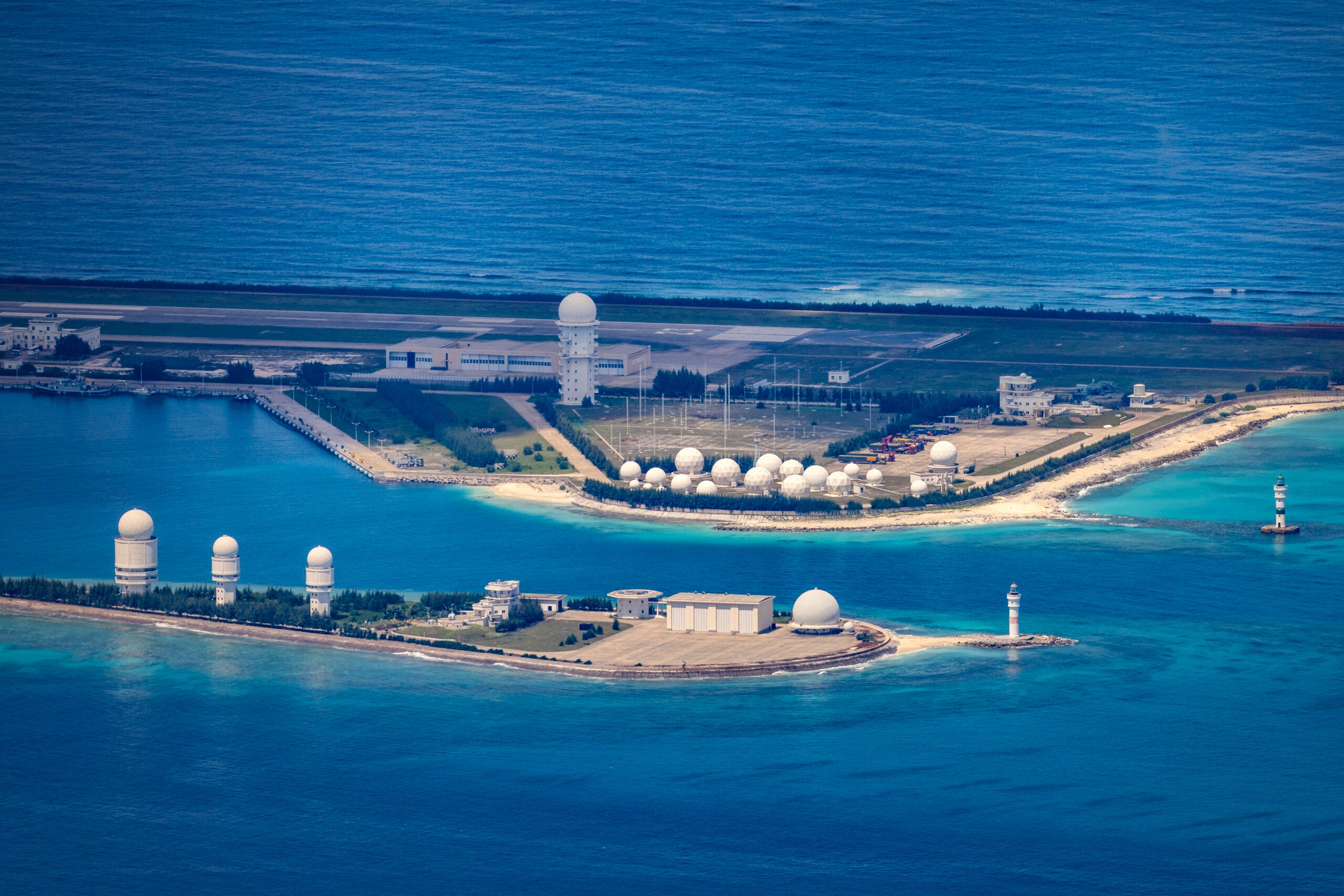 SPRATLY ISLANDS, AT SEA - OCTOBER 25: An airfield, buildings, and structures are seen on the artificial island built by China in Fiery Cross Reef on October 25, 2022 in Spratly Islands, South China Sea. China has progressively asserted its claim of ownership over disputed islands in the South China Sea by artificially increasing the size of islands, creating new islands and building ports, military outposts and airstrips. The South China sea is an important trade route and is of significant interest as geopolitical tensions remain high in the region. (Photo by Ezra Acayan/Getty Images)