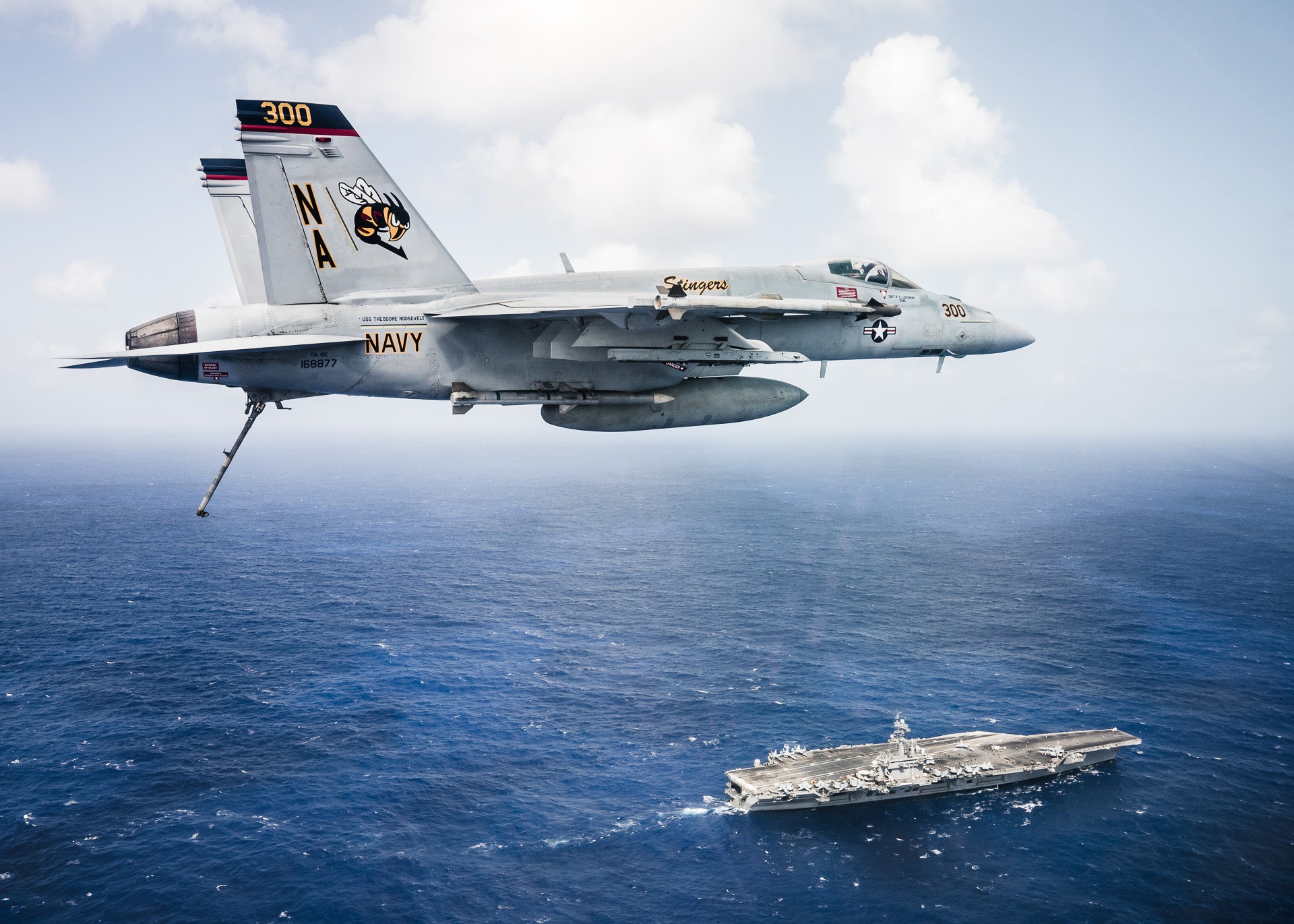 171026-N-TQ088-587 PACIFIC OCEAN (Oct. 26, 2017) An F/A-18E Super Hornet, assigned to the Stingers of Strike Fighter Attack Squadron (VFA) 113 flies over the aircraft carrier USS Theodore Roosevelt (CVN 71). The ship is underway for a regularly scheduled deployment in the U.S. 7th Fleet area of operations in support of maritime security operations and theater security cooperation efforts. (U.S. Navy photo by Lt. Aaron B. Hicks/Released)