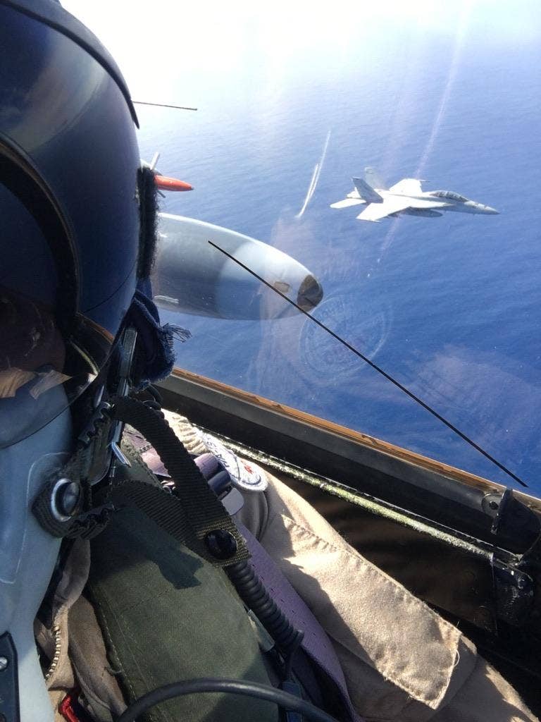 Three views showing a Navy F/A-18F Super Hornet flying alongside Kurtz’ Hunter.