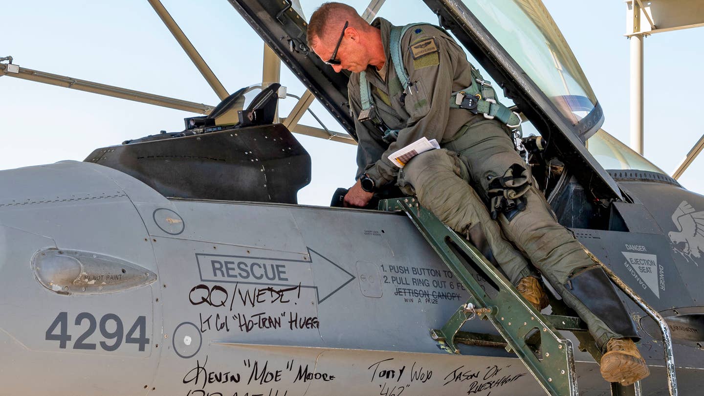 Lt. Col. Matthew “Fuse” Eldredge, 309th Fighter Squadron “Wild Ducks” former commander, prepares to fly a retiring Block 25 F-16 at Luke Air Force Base, Arizona, September 6, 2022. Signatures from commanders, honorary commanders, and other members of the “Ducks” cover the aircraft for its final send-off. <em>U.S. Air Force photo by Senior Airman David Busby</em>