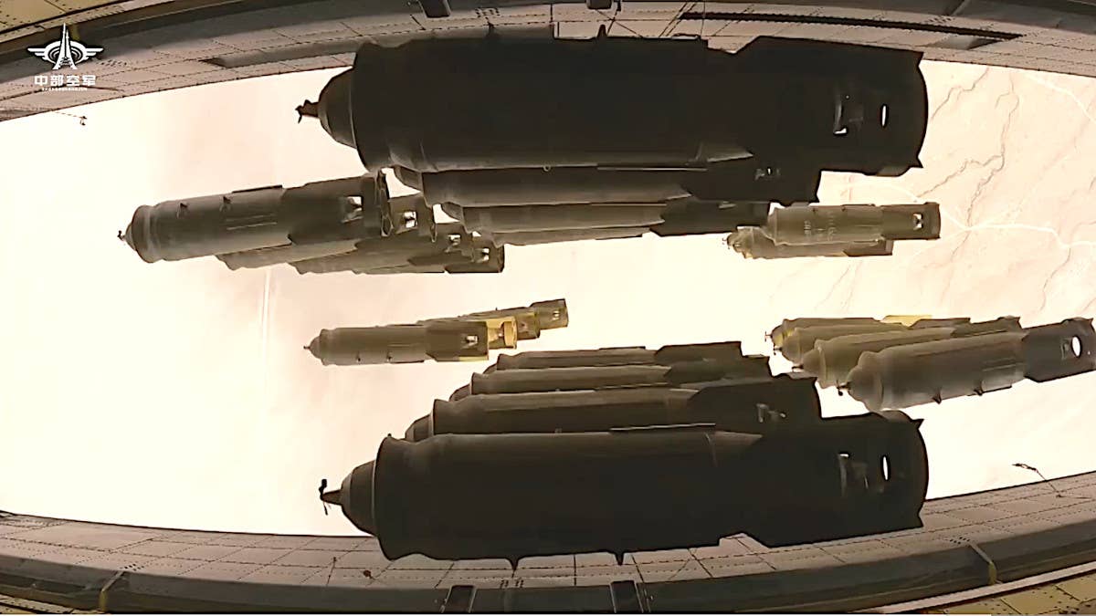 A screen grab from another clip in the recently released PLA video montage that shows unguided bombs falling from an H-6's bomb bay. Note the tail assemblies with the fins joined together at the very rear by a ring. <em>PLA capture</em>