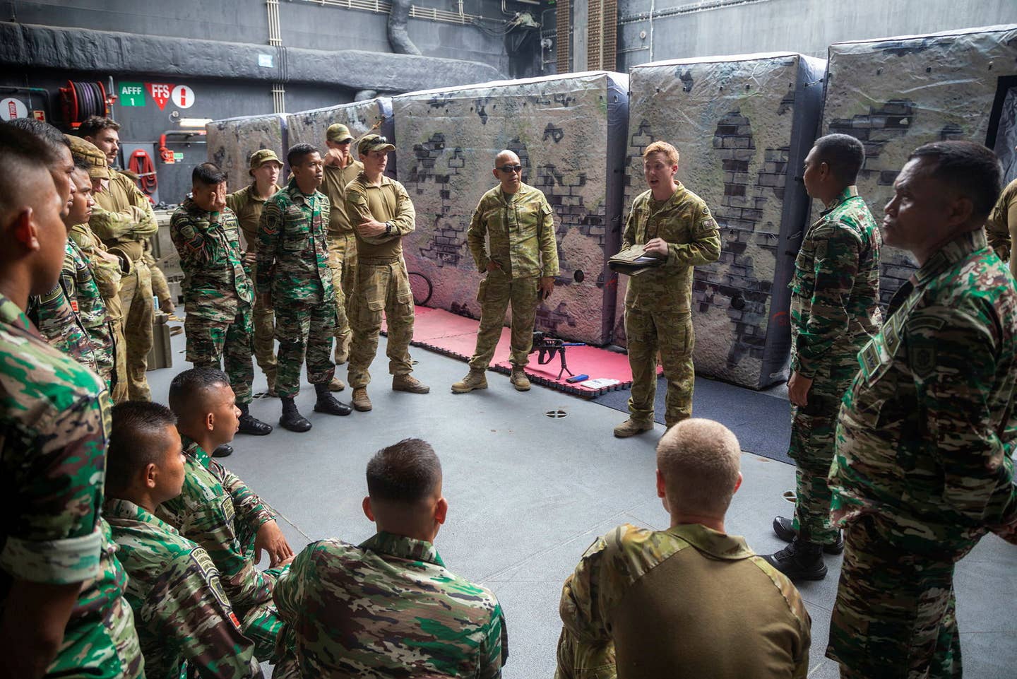 Australian and Indonesian soldiers receive a briefing before the training exercise begins. <em>Australian Department of Defense.</em>