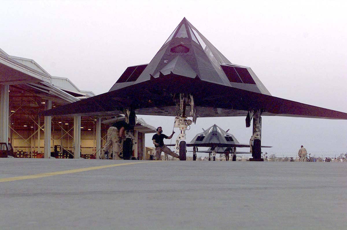 Several F-117 Nighthawks belonging to the 8th Fighter Squadron, 49th Fighter Wing, Holloman Air Force Base, New Mexico, being prepared for a mission on March 15, 1998. <em>USAF / Tech. Sgt. James D. Mossman</em>