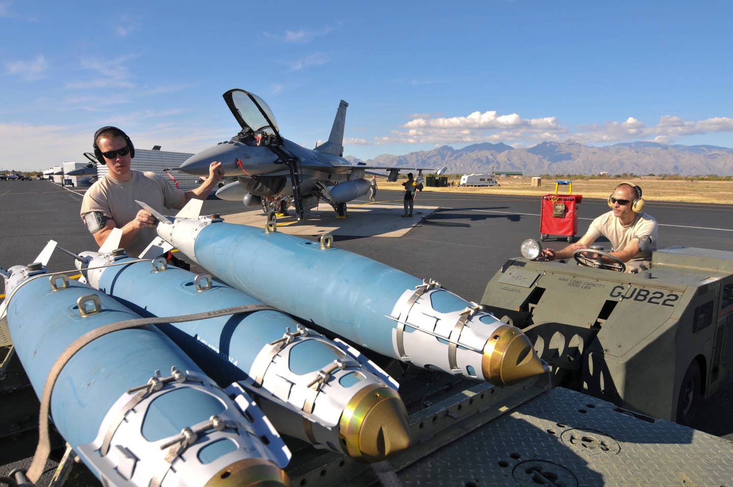 U.S. Air Force weapons loaders with the New Jersey Air National Guard load an inert 500-pound GBU-38 JDAM onto a weapons transport trailer at Davis-Monthan Air Force Base, Arizona. <em>U.S. Air National Guard photo by Master Sgt. Andrew J. Moseley/Released</em>