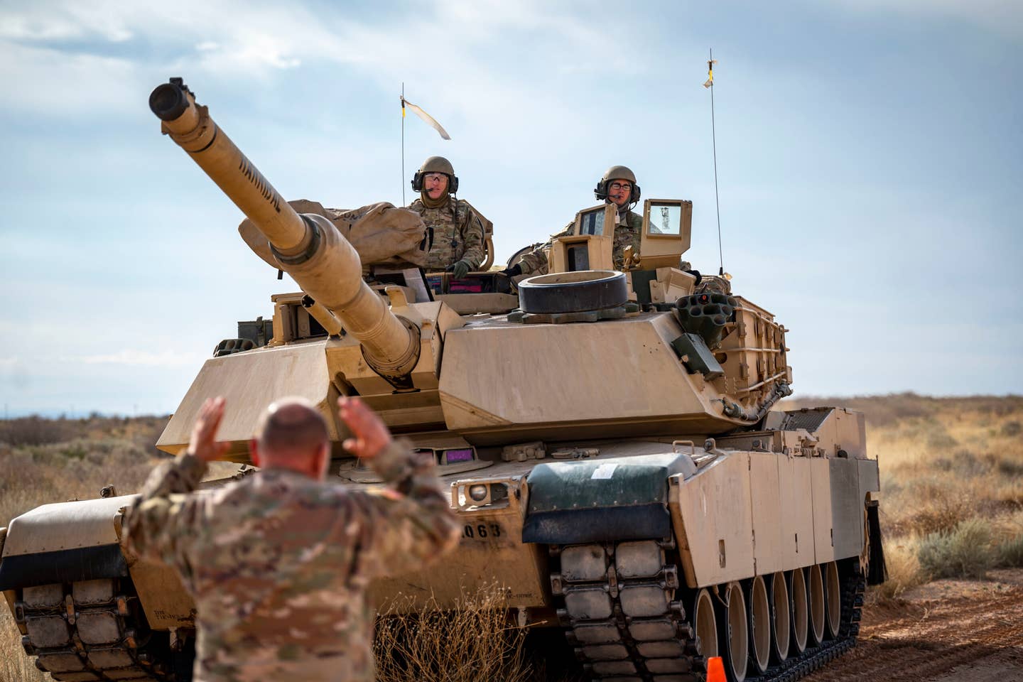 U.S. Army members assigned to the 1st Armored Division move an M1A2 Abrams tank into position to simulate receiving fuel from a 40th Airlift Squadron C-130J Super Hercules at Fort Bliss. <em>Credit: U.S. Air Force photo by Senior Airman Leon Redfern</em>