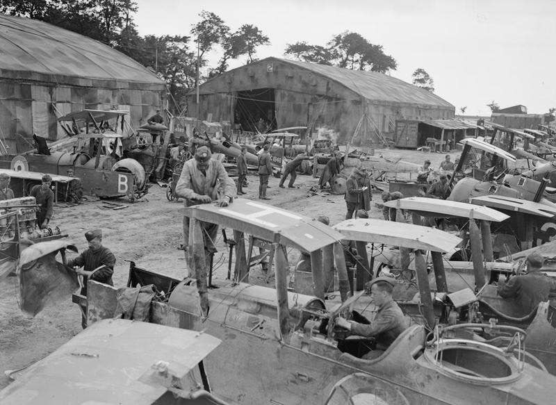 Mechanics working on wrecked fuselages of reconnaissance aircraft at the aircraft repair depot near Rang-du-Fliers, July 12, 1918. <em>David McLellan via Wikimedia Commons</em>