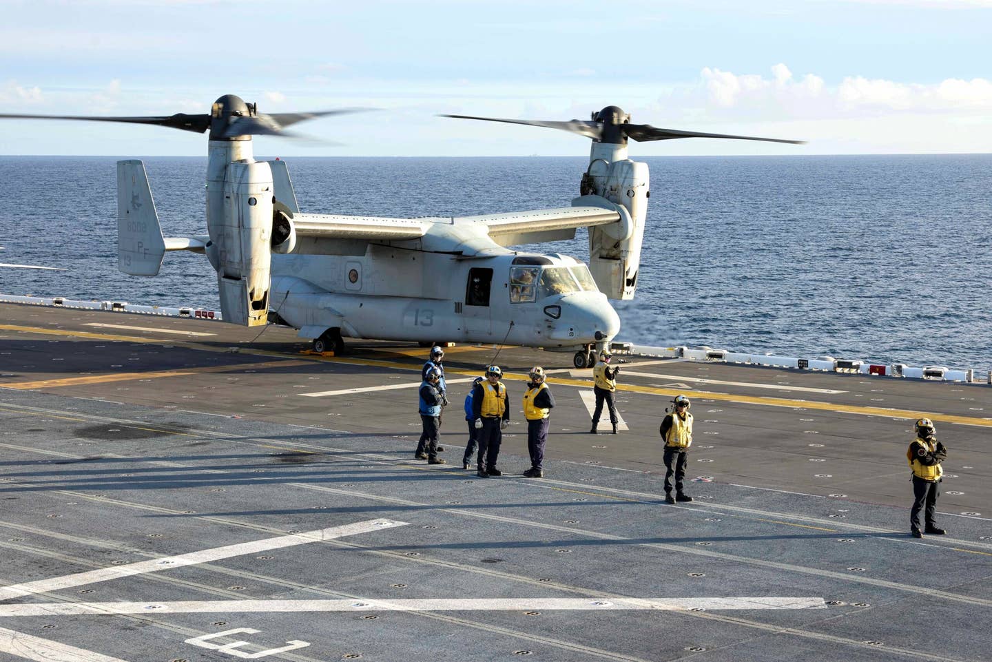 U.S. Navy Sailors with the amphibious assault ship USS <em>Tripoli</em> (LHA 7), chain down an MV-22B Osprey with Marine Medium Tiltrotor Squadron 364, Marine Aircraft Group 39, 3rd Marine Aircraft Wing (MAW), during exercise Steel Knight 2<em>i</em>, Dec. 5, 2022. Exercise Steel Knight provides 3rd MAW an opportunity to refine Wing-level warfighting in support of I Marine Expeditionary Force and fleet maneuver. (U.S. Marine Corps photo by Sgt. Samuel Fletcher) 