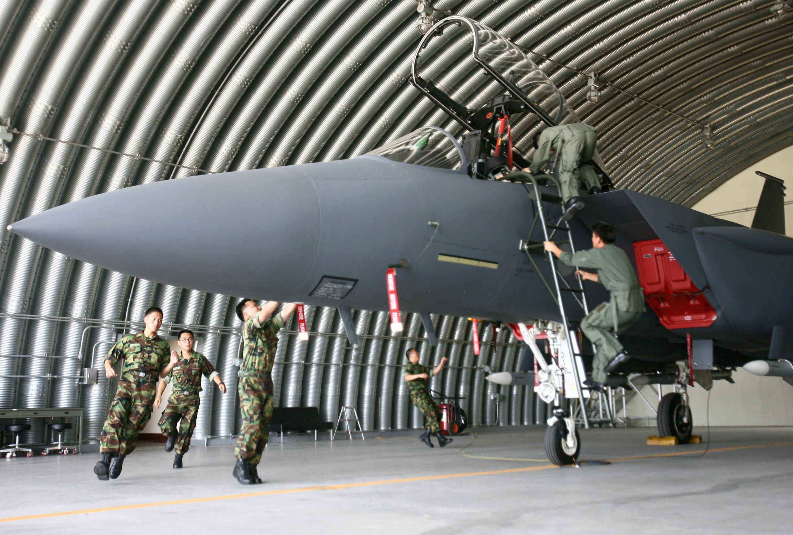South Korean air force maintenance staff check an F-15K fighter jet in an air base in the southern city of Daegu before its first deployment for combat operations on July 10, 2008. The deployment follows a period of pilot training and familiarisation since the air force began operating the planes in late 2005. AFP PHOTO/WON DAI-YEON (Photo credit should read WON DAI-YEON/AFP via Getty Images)