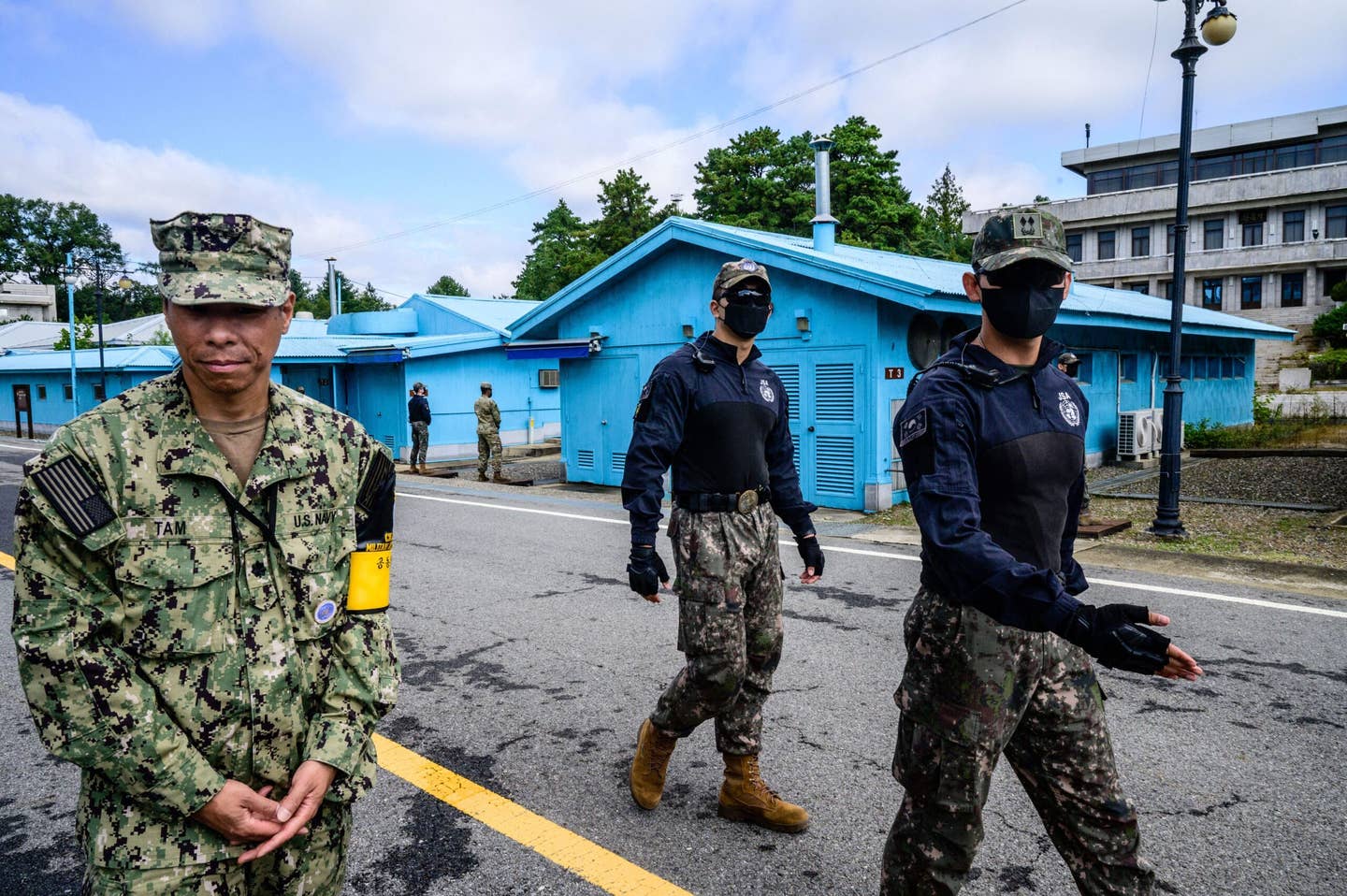 A United Nations Command) soldier (left) and South Korean troops walk in the Joint Security Area of the Demilitarized Zone in the truce village of Panmunjom on October 4, 2022. <em>Photo by ANTHONY WALLACE/AFP via Getty Images</em>
