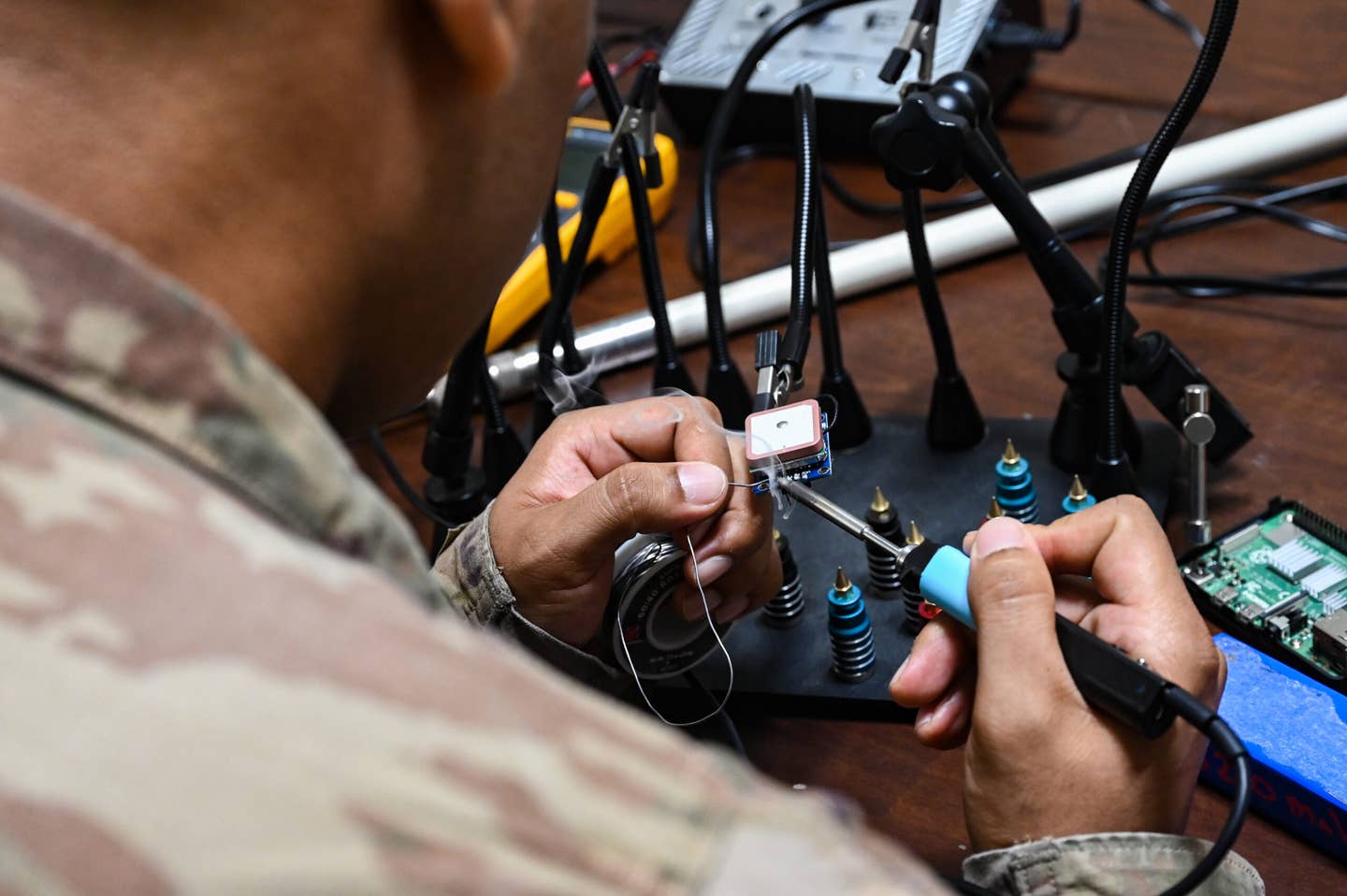 An Airman assigned to Task Force 99 solders components at Al Udeid Air Base, Qatar, October 28, 2022. <em>Credit: U.S. Air Force photo by Staff Sgt. Cassandra Johnson</em>