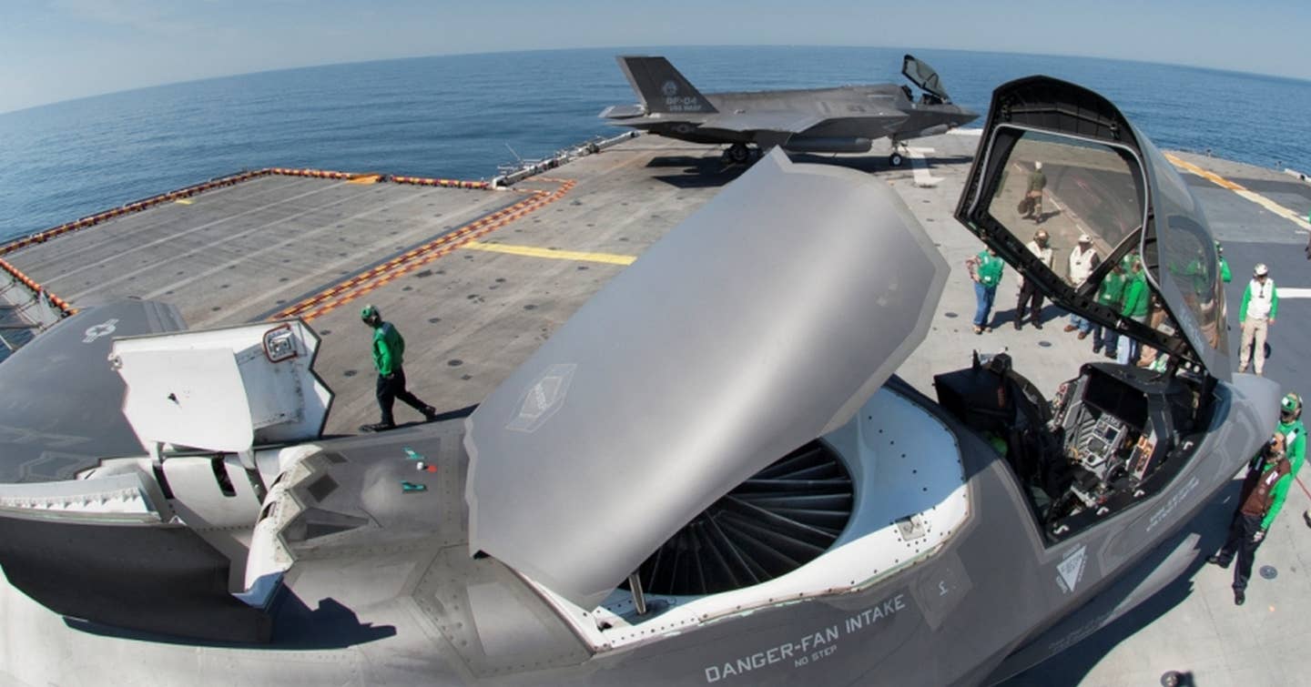 An F-35B on the USS <em>Wasp</em> with its lift fan door and auxiliary air inlet doors open atop the jet. (Lockheed Martin)