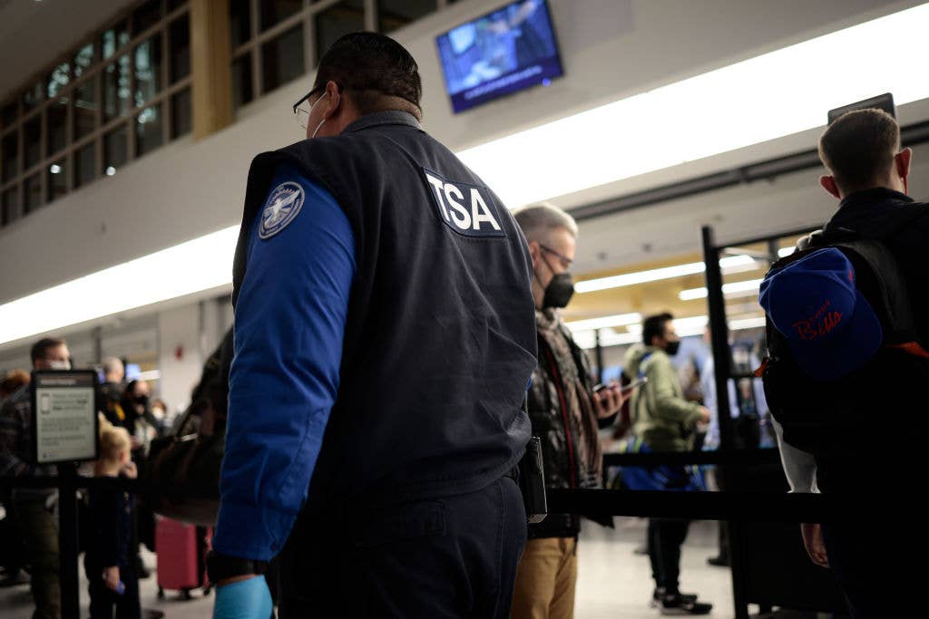 A TSA officer watches travelers go through a security checkpoint. <em>Credit: Photo by Anna Moneymaker/Getty Images</em>