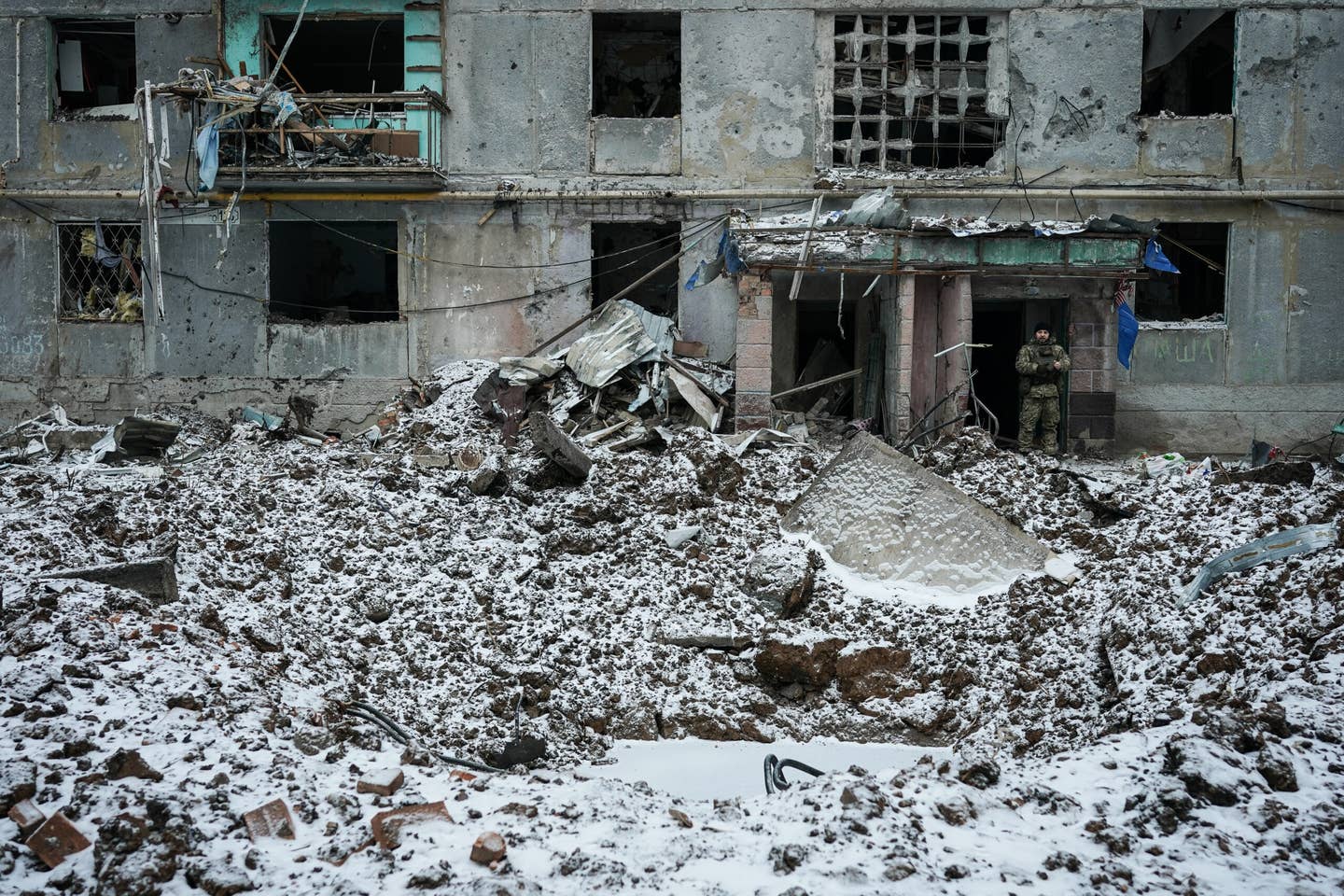 A Ukrainian soldier stands near the entrance to a destroyed residential building in Bakhmut. (Photo by Serhii Mykhalchuk/Global Images Ukraine via Getty Images)