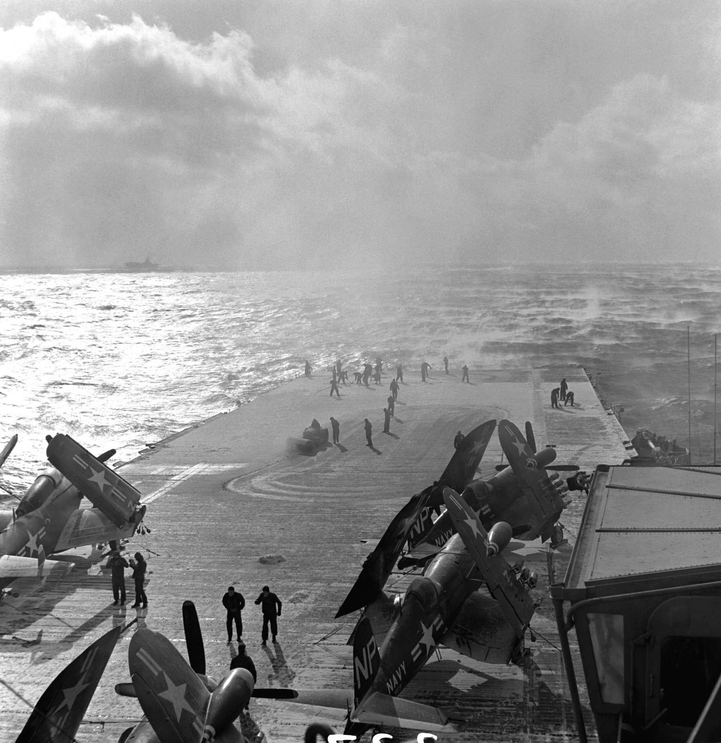Sailors clean snow off the flight deck of the aircraft carrier USS&nbsp;<em>Oriskany</em>&nbsp;off Korea, on February 10, 1953. Visible on deck are F4U-5N&nbsp;Corsair&nbsp;fighters and an AD-3W&nbsp;Skyraider&nbsp;airborne early warning aircraft. <em>U.S. National Archives</em>&nbsp;