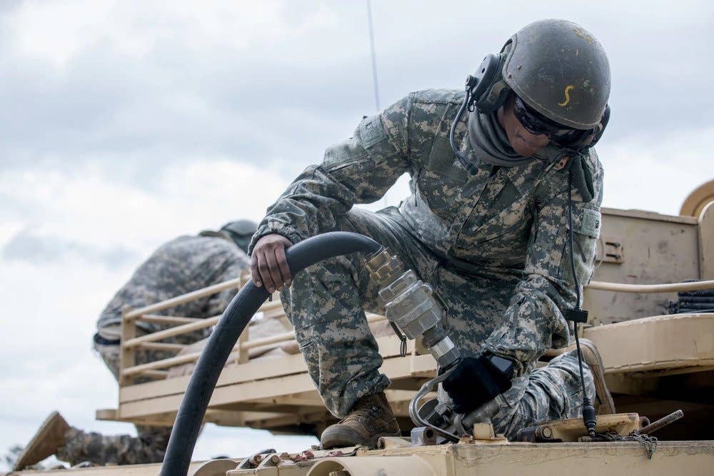 A U.S. Army Master Gunner Student, assigned to 3rd Squadron, 16th Calvary Regiment, uses a fuel hose to refuel a M1A2 SEP V2 Abrams Tank at Ware Range, Fort Benning, GA. (U.S. Army Reserve photo by Staff Sgt. Austin Berner)