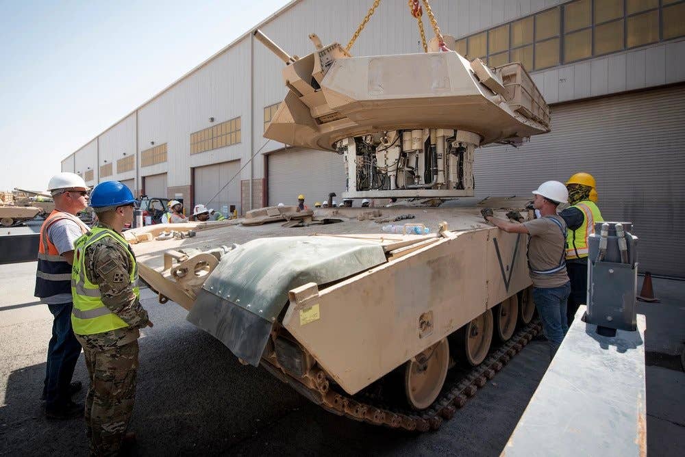 A maintenance crew at Army Prepositioned Stocks-5 works to reattach a 30-ton turret to an Abrams M1A2 tank, Camp Arifjan, Kuwait, Sept. 23. (Kevin Fleming photo)