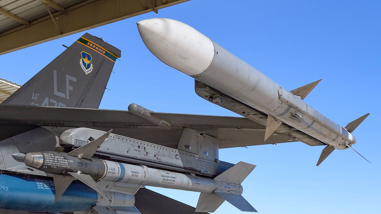 An AIM-9 Sidewinder (left) and AIM-120 AMRAAM (right) loaded on an F-16. <em>Jamie Hunter</em>