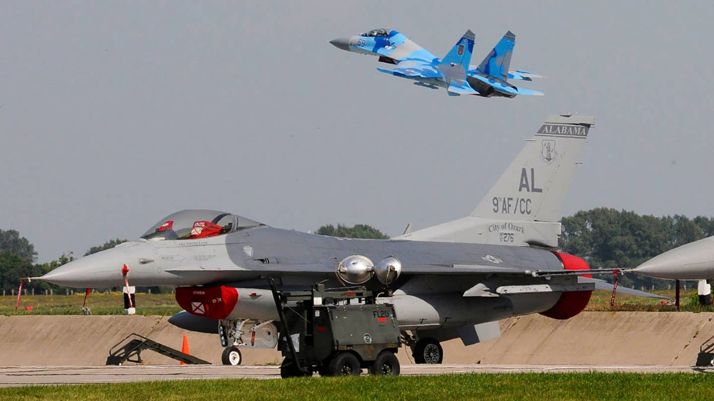 A Ukrainian SU-27 aircraft takes off from Mirgorod Air Base, Ukraine, July 20, 2011, while two Air National Guard F-16C Fighting Falcon aircraft rest in the foreground during Safe Skies 2011. (U.S. Air Force photo by Tech. Sgt. Charles Vaughn/Released)