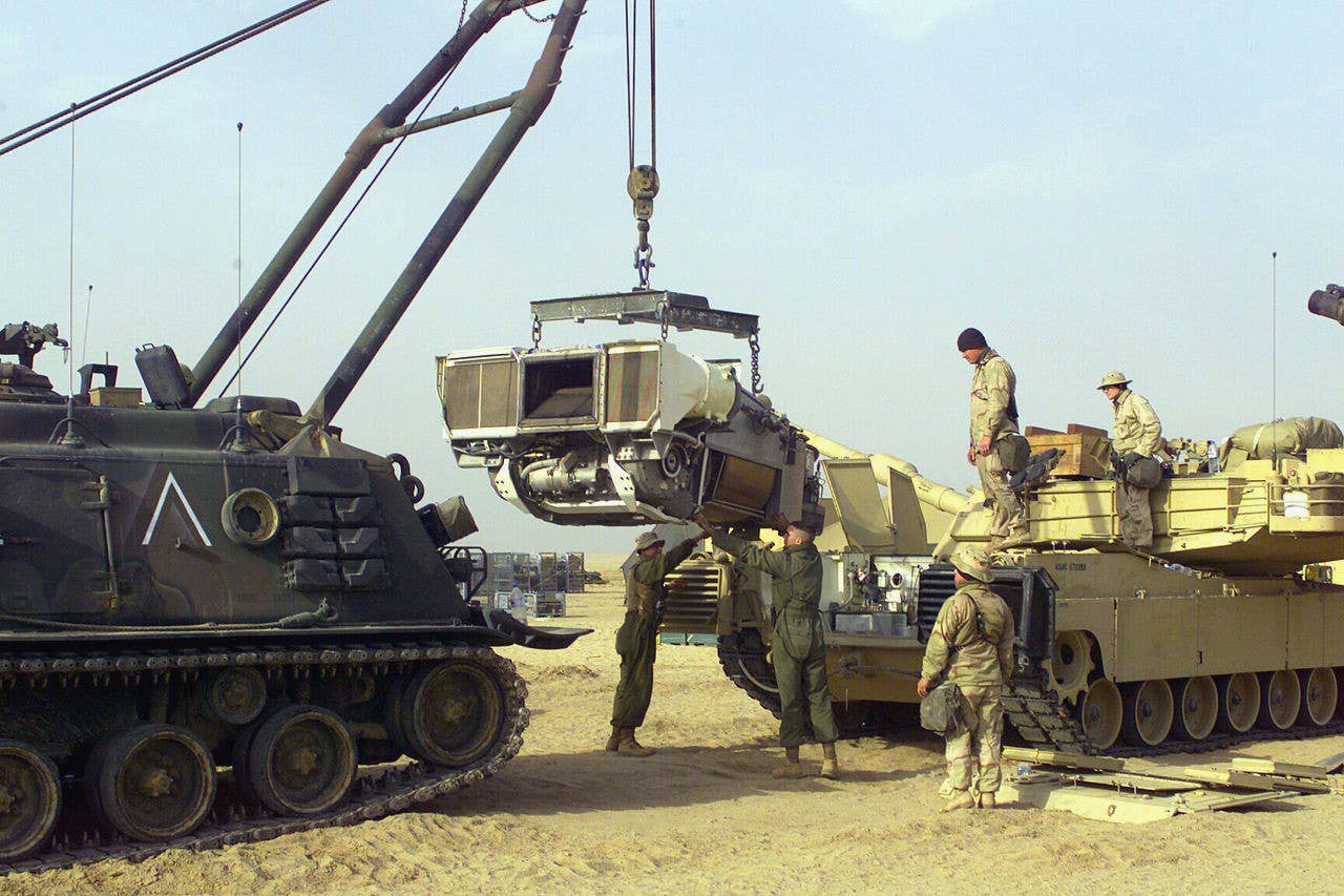 U.S. Marines use an M88 recovery vehicle to remove the FUPP from an M1 Abrams tank. <em>DOD</em>