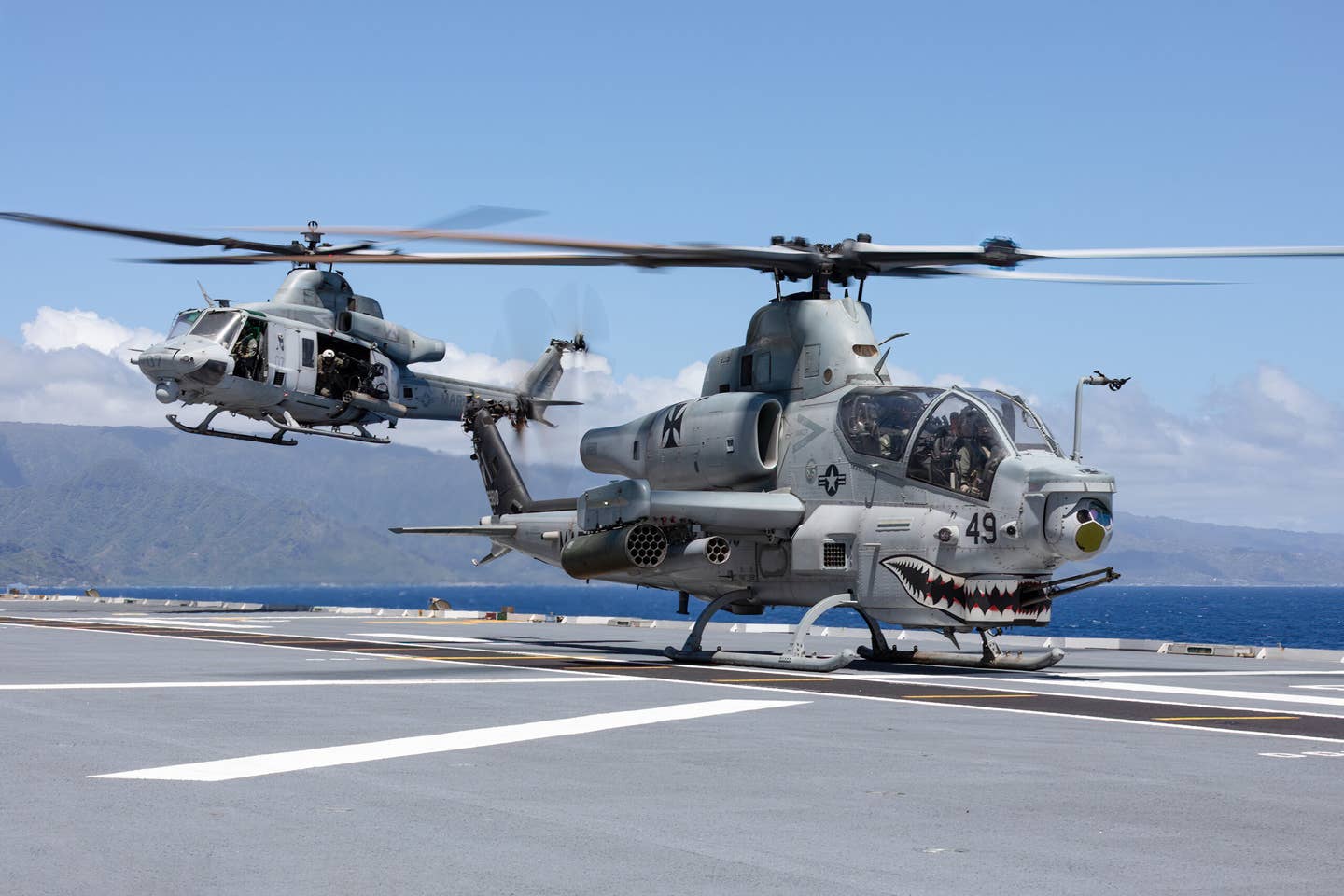 A U.S. Marine Corps UH-1Y Venom helicopter prepares to land beside a U.S. Marine Corps AH-1Z Viper helicopter on the flight deck of Royal Australian Navy Canberra-class landing helicopter dock HMAS Canberra. <em>Photo by Royal Australian Navy Leading Seaman Matthew Lyall</em>