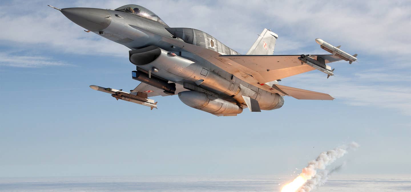 Carrying a Sniper pod and with CFTs fitted, a Polish F-16C armed with AMRAAM and AIM-9X missiles ejects an infrared flare. <em>Polish Armed Forces/Bartek Bera</em>