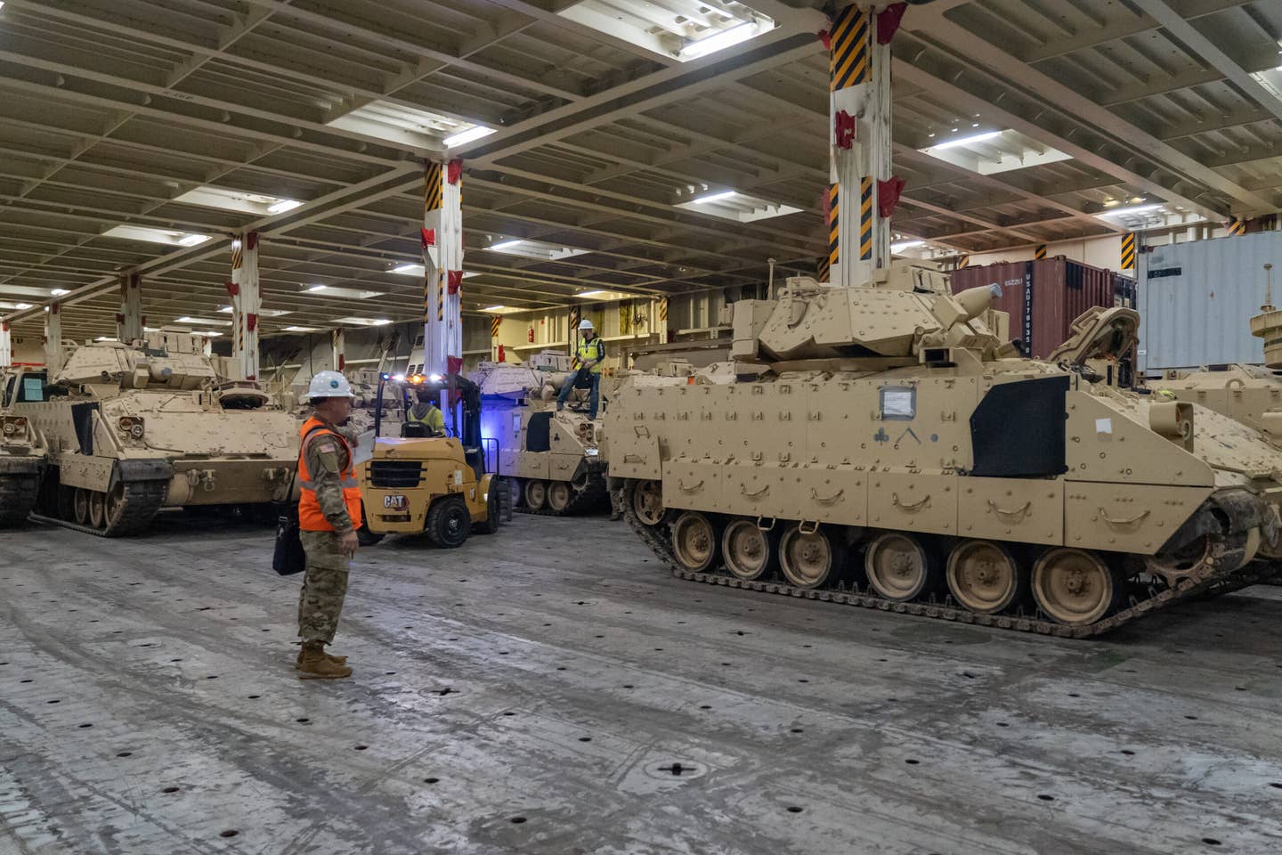 Army Sgt. Ryan Townsend, 841st Transportation Battalion operations hatch foreman, inspects Bradley Fighting Vehicles as they are parked within the ARC Integrity, Jan. 25. (U.S. Transportation Command photo by Oz Suguitan)