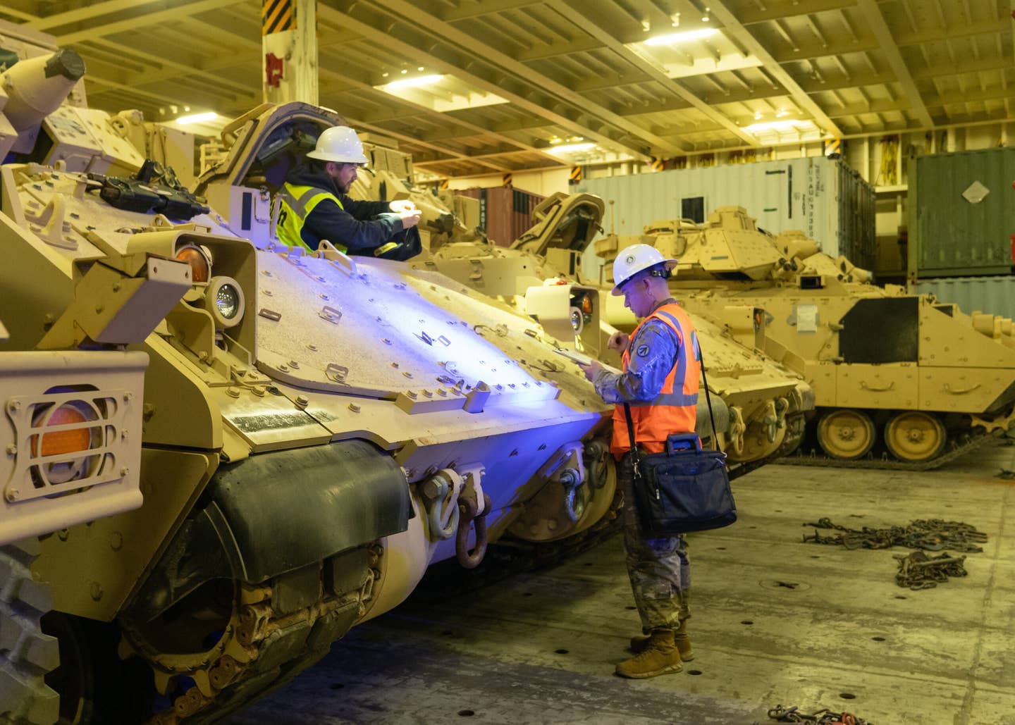 Army Sgt. Ryan Townsend, 841st Transportation Battalion operations hatch foreman, helps prepare a Bradley Fighting Vehicle for overseas transport, Jan. 25, 2023, at the Transportation Core Dock in North Charleston, South Carolina. (U.S. Transportation Command photo by Oz Suguitan)