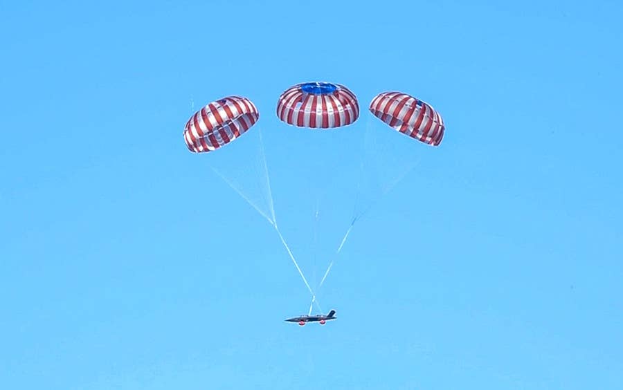 An XQ-58A descending under its parachutes after a mission. <em>Kratos</em>