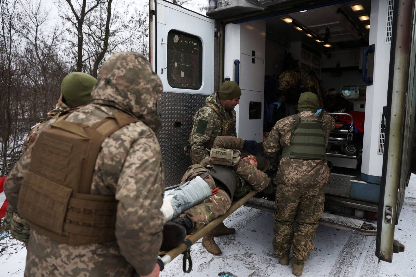 Medics of the Ukrainian Army evacuate a wounded soldier on a road near Soledar, Oblast on Jan. 14, 2023. (Photo by ANATOLII STEPANOV/AFP via Getty Images)