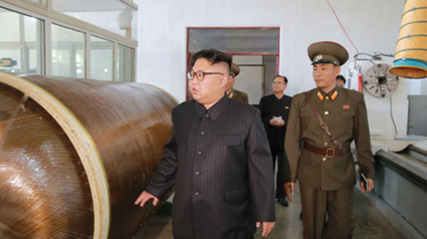 Kim Jong Un walks past what appears to be a wound filament rocket motor casing, related to a solid-fuel rocket motor for a smaller type of ballistic missile, in 2019.&nbsp;<em>KCNA</em>