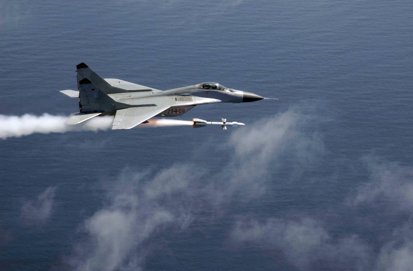 A German Luftwaffe MiG-29 fires a radar-guided R-27R air-to-air missile at a QF-4 full-scale aerial target drone during a live-fire weapons training mission in the United States. <em>U.S. Air Force</em>