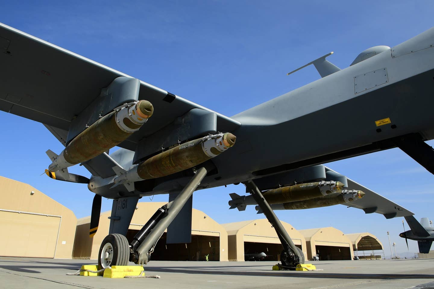 An MQ-9 Reaper, assigned to the 62nd Expeditionary Reconnaissance Squadron, armed with four GBU-38 JDAMs parks on a flight line. <em>Credit: U.S. Air Force Photo by Tech. Sgt. Paul Labbe</em>