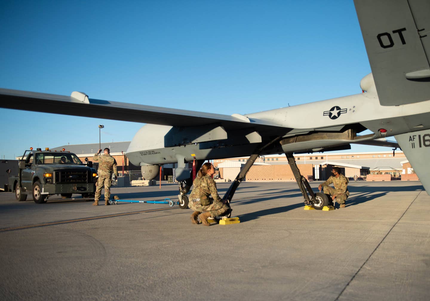 U.S. Air Force Airmen assigned to the 432d Maintenance Squadron prepare the MQ-9 to be attached to the tow truck so it can be towed into the hanger on the flightline at Creech Air Force Base, Nov. 23, 2021. <em>Credit: U.S. Air Force photo by Airman 1st Class Kristal Munguia</em>