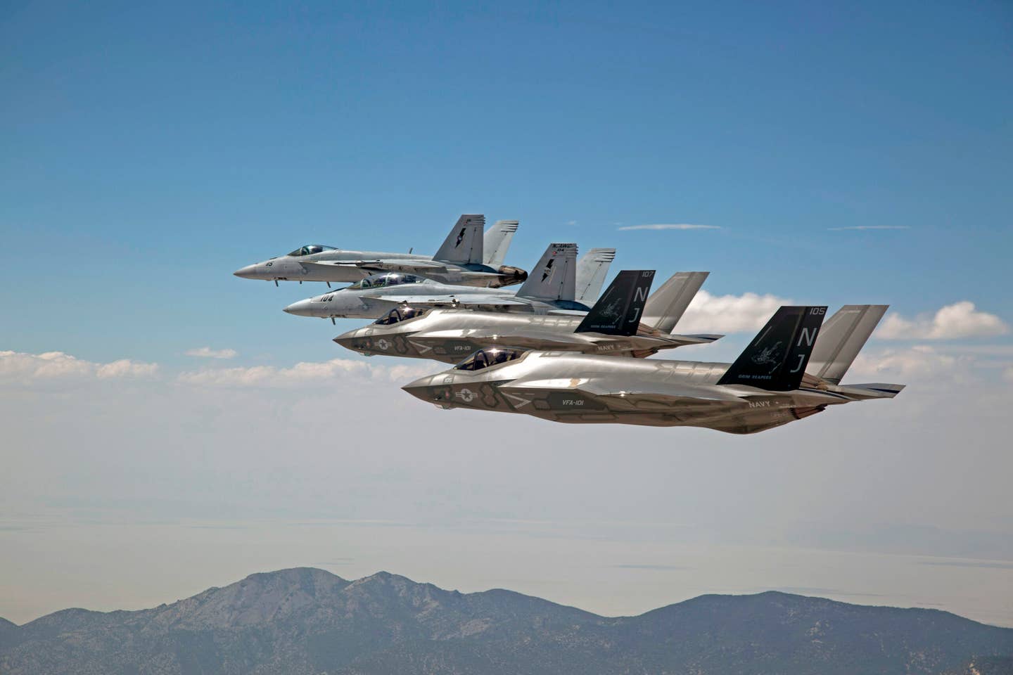 F-35Cs, attached to VFA-101 “Grim Reapers,” and F/A-18E/F Super Hornets attached to the Naval Aviation Warfighter Development Center (NAWDC) fly over Naval Air Station Fallon’s Range Training Complex. <em>U.S. Navy photo by Lt. Cmdr. Darin Russell/Released</em>