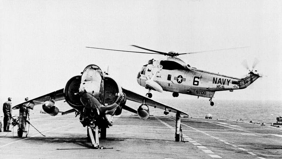 An AV-8A Harrier from VMA-531 and an SH-3A Sea King from HS-15 aboard the U.S. Navy amphibious assault ship USS <em>Guam</em> (LPH-9) in January 1972. <em>U.S. Navy</em>