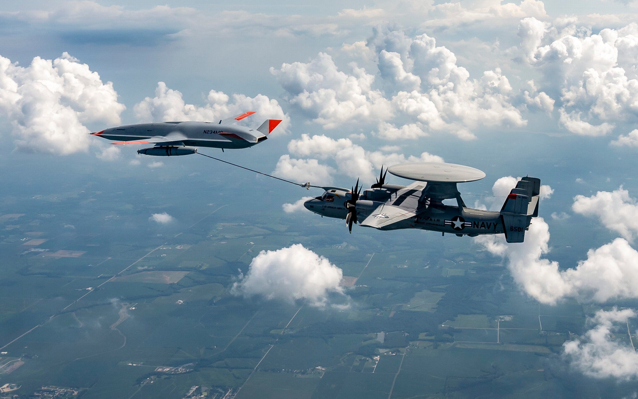 MASCOUTAH, Ill. (Aug. 18, 2021) An MQ-25 Stingray unmanned aerial vehicle refuels an E-2D Advanced Hawkeye aircraft over MidAmerica Airport in Mascoutah, Ill,, Aug. 18, 2021. This test marks the second successful refueling flight for the MQ-25 program. The six-hour flight, conducted by Air Test and Evaluation Squadron (VX) 20, tested the Boeing-owned MQ-25 test asset's fuel transfer, formation evaluations, wake surveys, drogue tracking and plugs at 220 knots calibrated airspeed at 10,000 feet. (U.S. Navy photo courtesy of Boeing