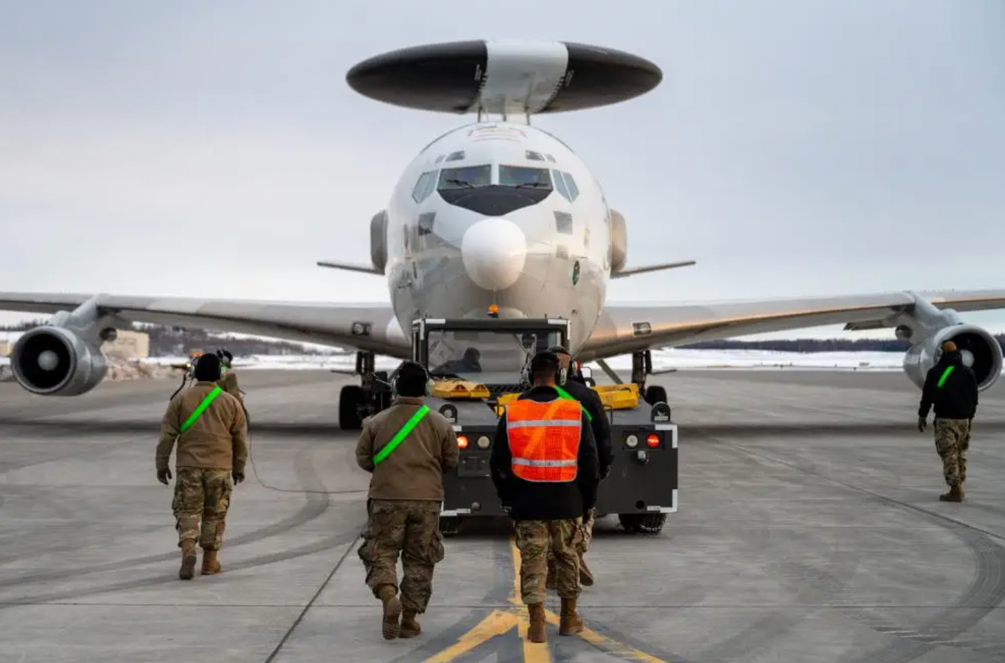 U.S. airmen assigned to the 962nd Aircraft Maintenance Unit monitor an E-3 AWACS as the aircraft is towed at Joint Base Elmendorf-Richardson, Alaska, on March 22, 2022. <em>U.S. Air Force photo by Airman 1st Class Andrew Britten</em><br>