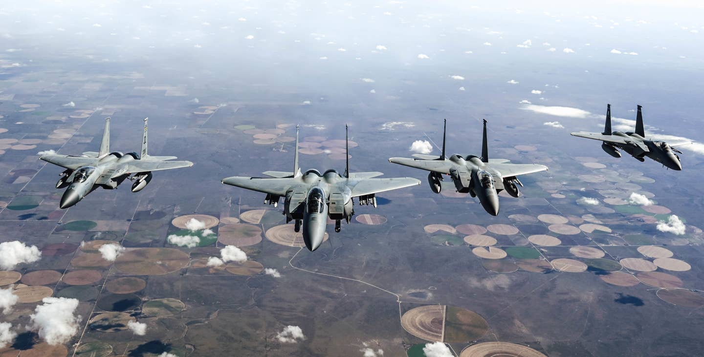 Three F-15Cs and an F-15EX assigned to the 85th Test and Evaluation Squadron, Eglin Air Force Base, Florida, fly behind a KC-135 assigned to the 465th Air Refueling Squadron, Tinker AFB, Oklahoma, Oct. 15, 2021. (U.S. Air Force illustration by 2nd Lt. Mary Begy)