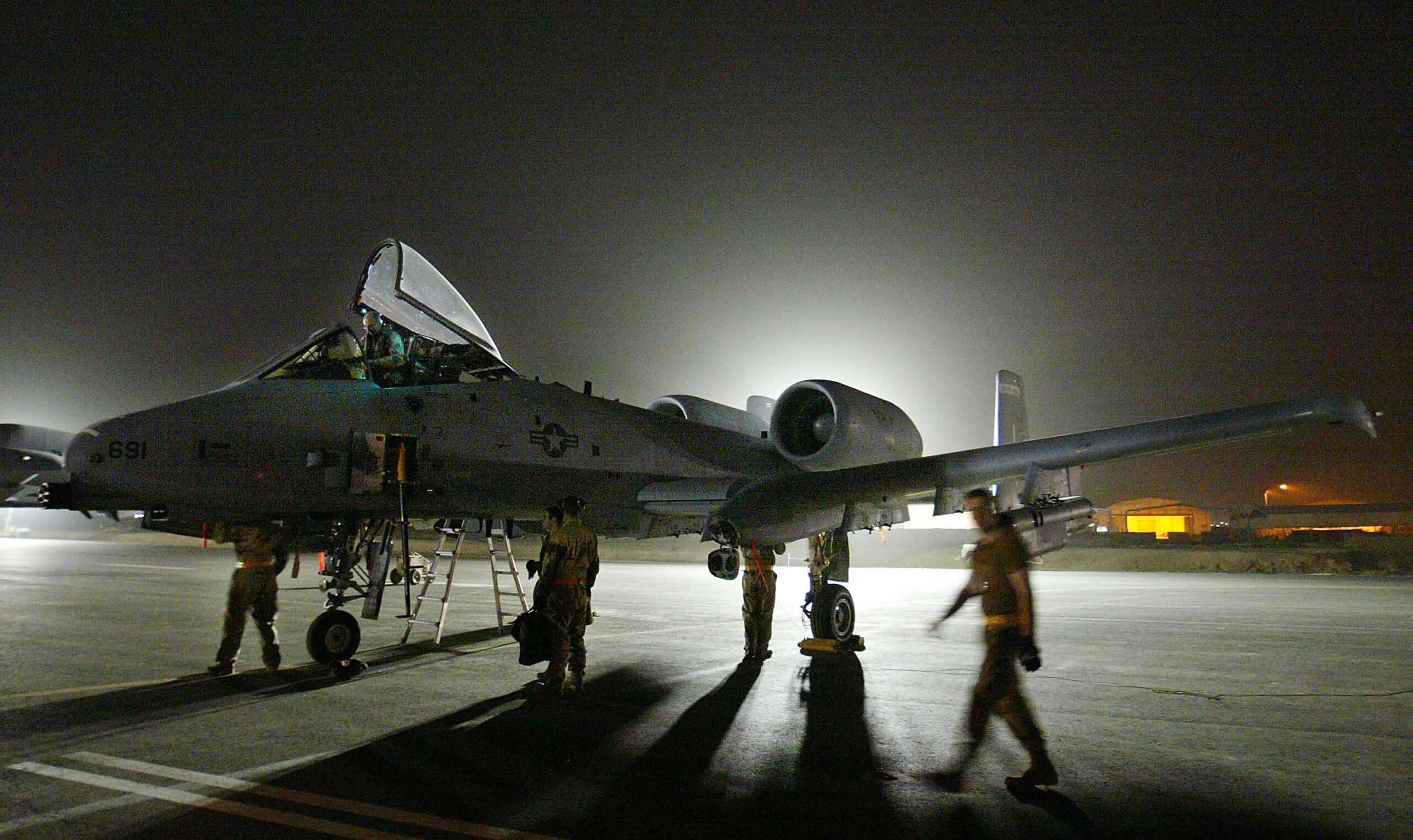 UNDISCLOSED AIRBASE, ARABIAN GULF - MARCH 19:  Air Force maintenance personnel go through pre-flight checks on an A-10 Warthog tank killer plane as work goes on through the night March 19,2003 at an airbase in the Arabian Gulf. More than 250,000 troops, a naval armada and an estimated 1,000 combat aircraft are in the region, ready to strike Iraq when the U.S. President George W. Bush gives the word.  (Photo by Paula Bronstein/Getty Images)